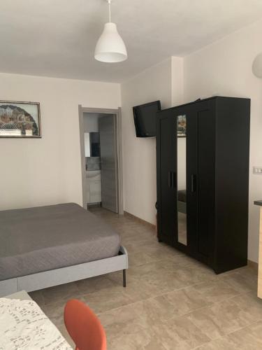 a bedroom with a bed and a black cabinet at CASA VACANZE gli ULIVI 23 in Sìnnai