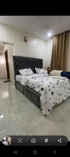 a bedroom with a bed with a black and white comforter at Optimist villa in Ilorin