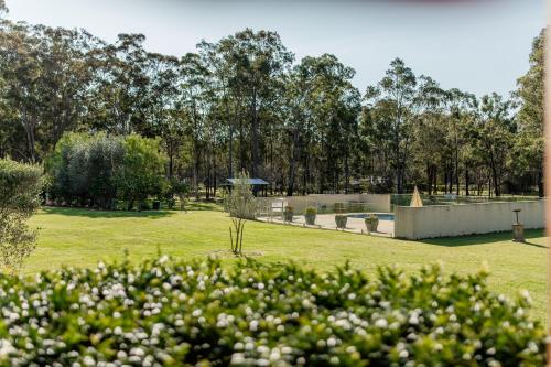 a park with white flowers in a field at Chez Vous Villas Pokolbin in Pokolbin