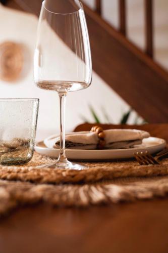 a glass of wine sitting on a table with a plate at Le Pré de la Mer Suite & SPA Privatif in Querqueville