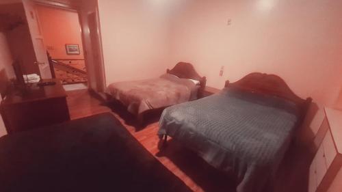 a bedroom with two beds and a stairway with a staircase at Hotel Luis cordero centro historico cuenca in Cuenca