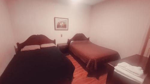 a room with two beds and a table at Hotel Luis cordero centro historico cuenca in Cuenca
