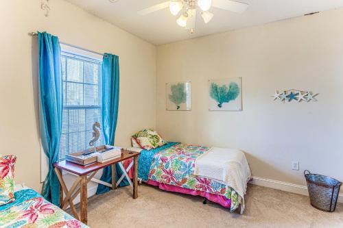 Un dormitorio con dos camas y una mesa y una ventana. en Golf Getaway by Casino, Dolphin Cruises and Beach!, en Little River