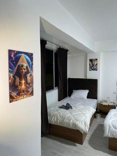 a bedroom with a bed and a painting on the wall at Retaj Pyramids View in Cairo