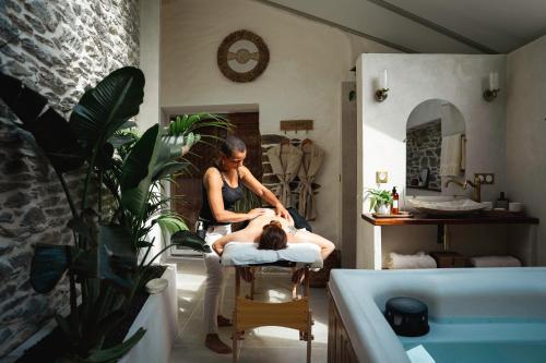 a woman sitting in a chair in a bathroom at Le Pré de la Mer Suite & SPA Privatif in Querqueville