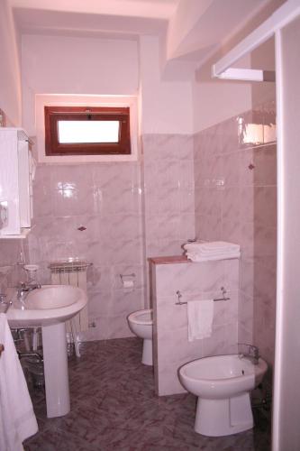 a bathroom with a sink and a toilet and a sink at Hotel Ristorante Giardino in Abbadia San Salvatore