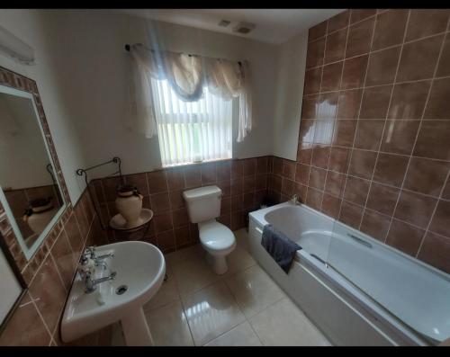 a bathroom with a tub and a toilet and a sink at Carndonagh - 3-Bedrooms - Sleeps 6 7 - Garden in Carndonagh