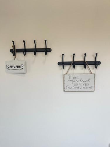 a sign is hanging on a wall next to a wall at Maison du Vignoble in Pfaffenheim