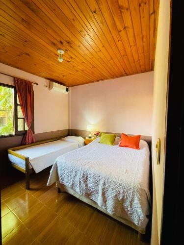 Un dormitorio con dos camas y techo de madera. en Dpto Cómodo Céntrico Iguazú 1Y, en Puerto Iguazú