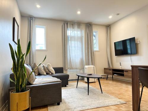 a living room with a couch and a tv at Lovely One-Bedroom in Vibrant Plateau Mont-Royal in Montréal