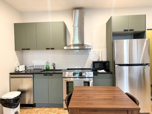 a kitchen with stainless steel appliances and a wooden table at Lovely One-Bedroom in Vibrant Plateau Mont-Royal in Montréal
