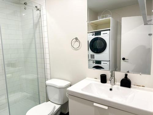 a bathroom with a toilet and a sink and a microwave at Lovely One-Bedroom in Vibrant Plateau Mont-Royal in Montréal