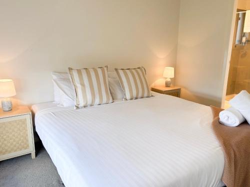 a bedroom with a large white bed with two pillows at 3 Bed in Boorooma in North Wagga