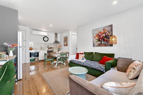 a living room with a green couch and a kitchen at Fingal 1BR Sleeps 5 Apartment 28, Golf ,Beach, Hot Springs in Fingal