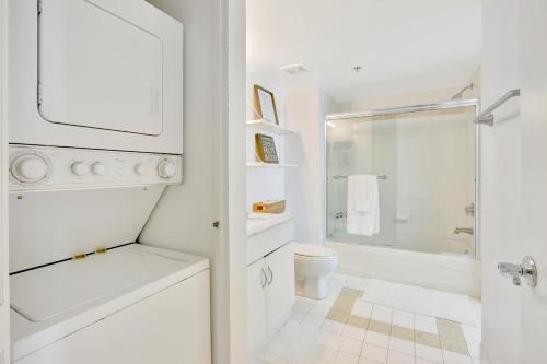 a white bathroom with a sink and a toilet at The Bay Suites - Brickell in Miami
