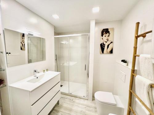 a white bathroom with a sink and a shower at Apartamento con piscina y terraza recién reformado in Platja  d'Aro
