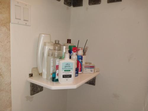 a shelf in a bathroom with bottles on it at Private Guest House 2 bedrooms & 2 baths near Grace Bay Beach & Long Bay Beach. in Providenciales
