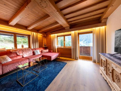 a living room with a red couch and some windows at City Hide-Away in Kitzbühel