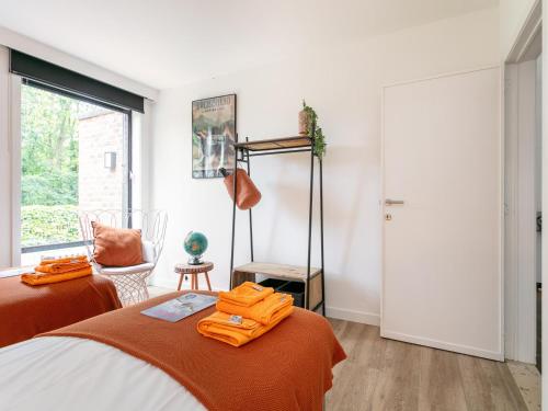 a bedroom with a bed with an orange blanket at Maison Clement in Maasmechelen