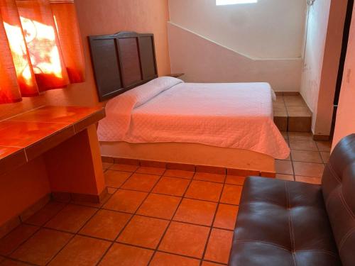 a small bedroom with a bed and a couch at Casa 12 Reales in Guanajuato