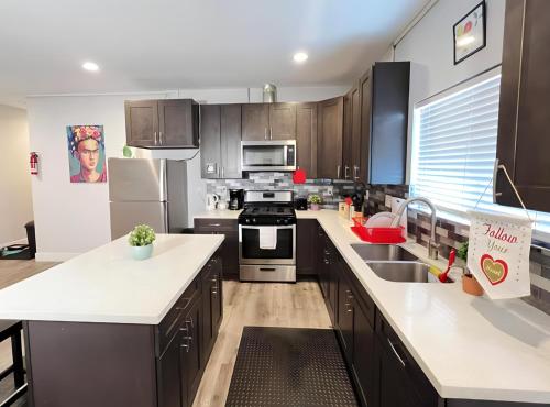 a kitchen with black cabinets and white counter tops at Twin Pineapple Hostel in Los Angeles