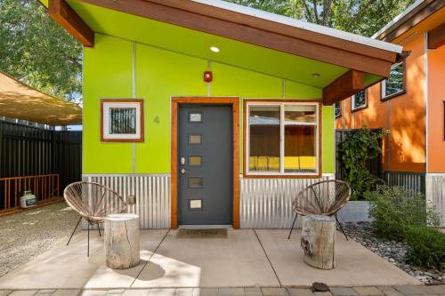 a green house with two chairs and a door at Downtown Kokopelli West 4 - Newly Remodeled Stylish Studio in Moab