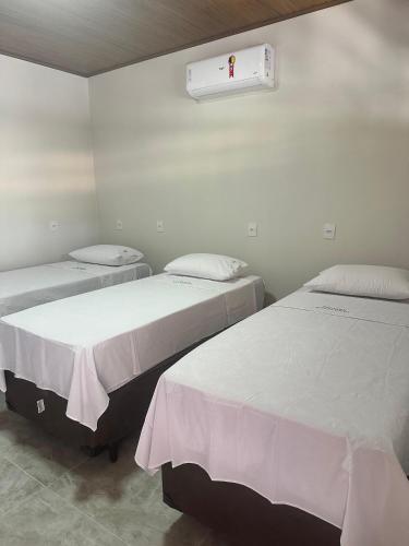 a room with two beds and a heater on the wall at Pousada Canta Galo in Goiás