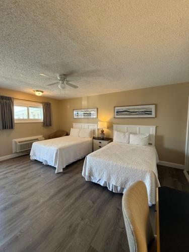 a bedroom with two beds and a table and chairs at Point Pleasant Manor in Point Pleasant Beach