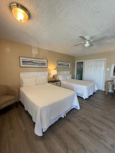 a bedroom with two beds and a ceiling fan at Point Pleasant Manor in Point Pleasant Beach