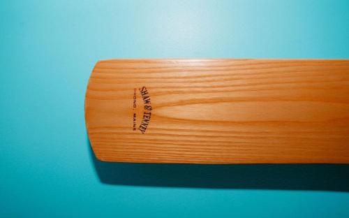 a wooden surfboard sitting on top of a blue wall at Saltwood Peterborough in Peterborough