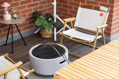 a patio with a grill and a chair and a table at Lala Posh#수원#삼성전자#행궁동#2룸 in Seryu-dong