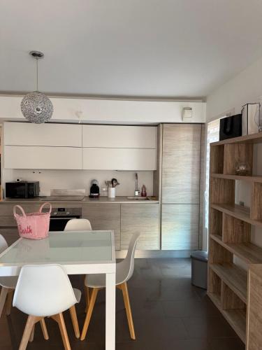 a kitchen with a white table and white chairs at Maison Marquet in Cap d'Ail