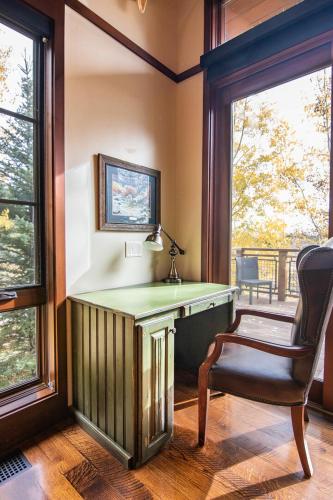 a desk with a chair in a room with windows at RMR: Timbers at Granite Ridge 3100 in Teton Village in Teton Village