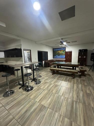 an empty room with tables and a flat screen tv at Finca de recreo en Alcalá valle in Alcalá