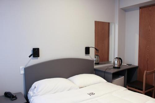 a bedroom with a bed and a desk with a telephone at Hotel Balfers in Montevideo