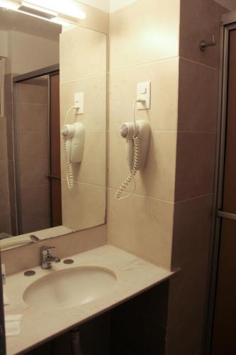 a bathroom with a sink and a phone on the wall at Hotel Balfers in Montevideo