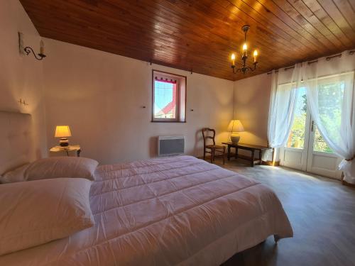 a bedroom with a large bed and a wooden ceiling at Maison de vacances en Berry avec jardin clos, proche plage et sentiers, animaux acceptés - FR-1-591-319 in Baraize