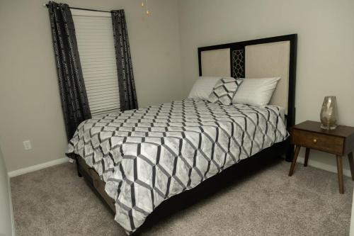 a bedroom with a bed with a black and white comforter at Private Room in Richmond, TX in Richmond