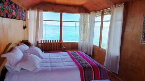 a bedroom with a bed with a view of the ocean at Totora Wasi in Puno