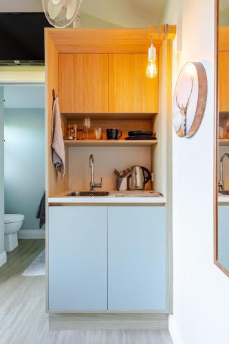 a kitchen with white cabinets and a sink at Wellington Inner City Hideaway-Walk to Everything! in Wellington