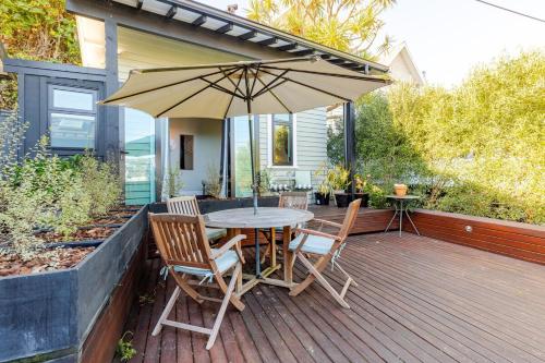 a table and chairs with an umbrella on a deck at Wellington Inner City Hideaway-Walk to Everything! in Wellington