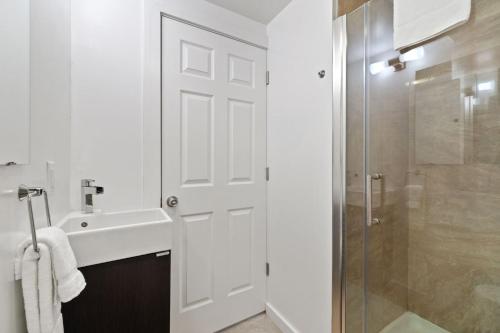 a white bathroom with a sink and a shower at RMR: Tensleep B4 Condo in Teton Village in Teton Village