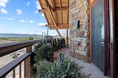 a balcony with plants and a stone building at RMR: Crystal Springs 401 Condo in Teton Village in Teton Village