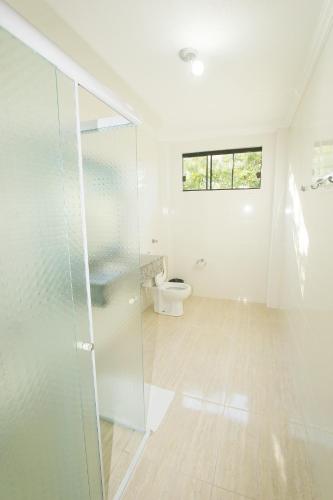a bathroom with a glass shower and a toilet at Pousada São Gerônimo in Matinhos