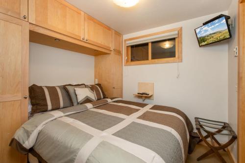 a bedroom with a bed and a tv on the wall at RMR: La Choumine 2 Condo in Teton Village in Teton Village
