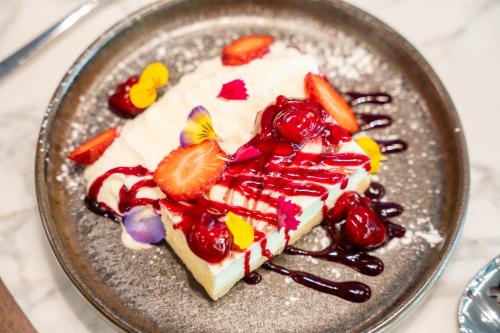 a piece of cake with fruit on a plate at Distinction Invercargill Hotel in Invercargill