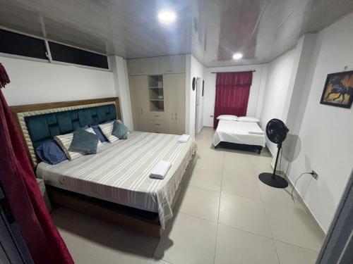 una camera da letto con un letto grande in una stanza di Habitación en casa campestre con piscina a Villavicencio