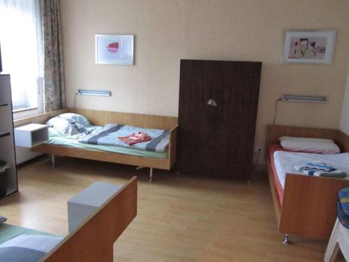 a small room with two beds and a cabinet at for fitters in the Hunsrück in Benzweiler