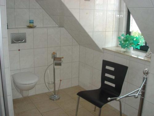 baño con aseo y silla negra en Holiday home in Waren with swimming pool, en Waren