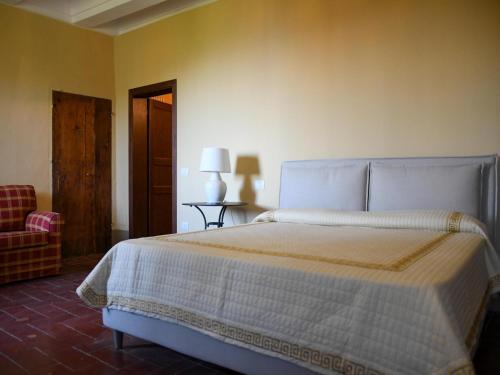 Fiorenzuola di FocaraにあるLarge apartment in a stone farmhouseのベッドと椅子のある寝室